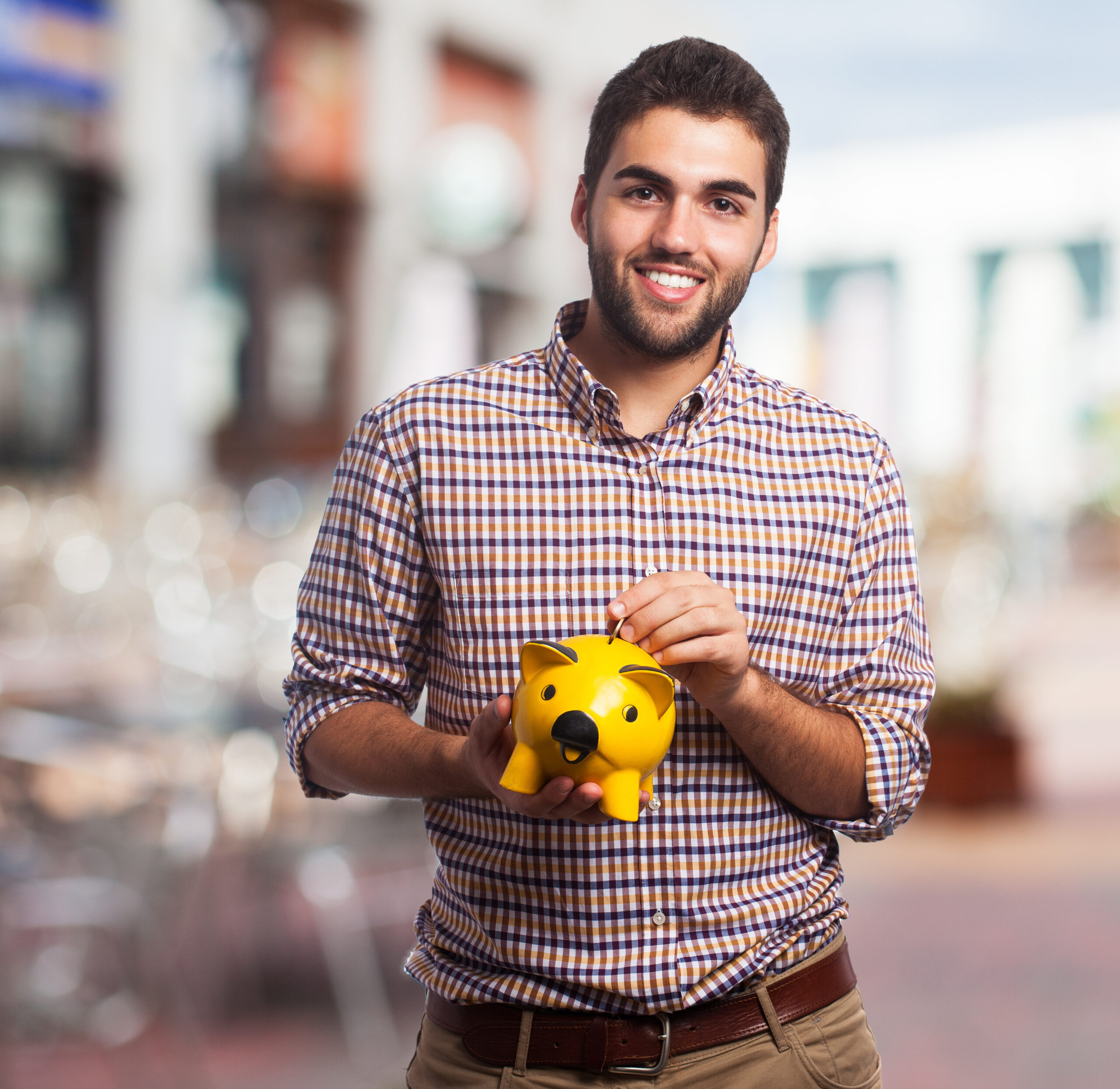 portrait of a young man holding a piggy bank